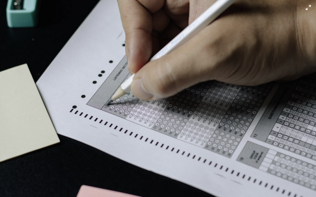 Close up photo of a person filling out a scantron